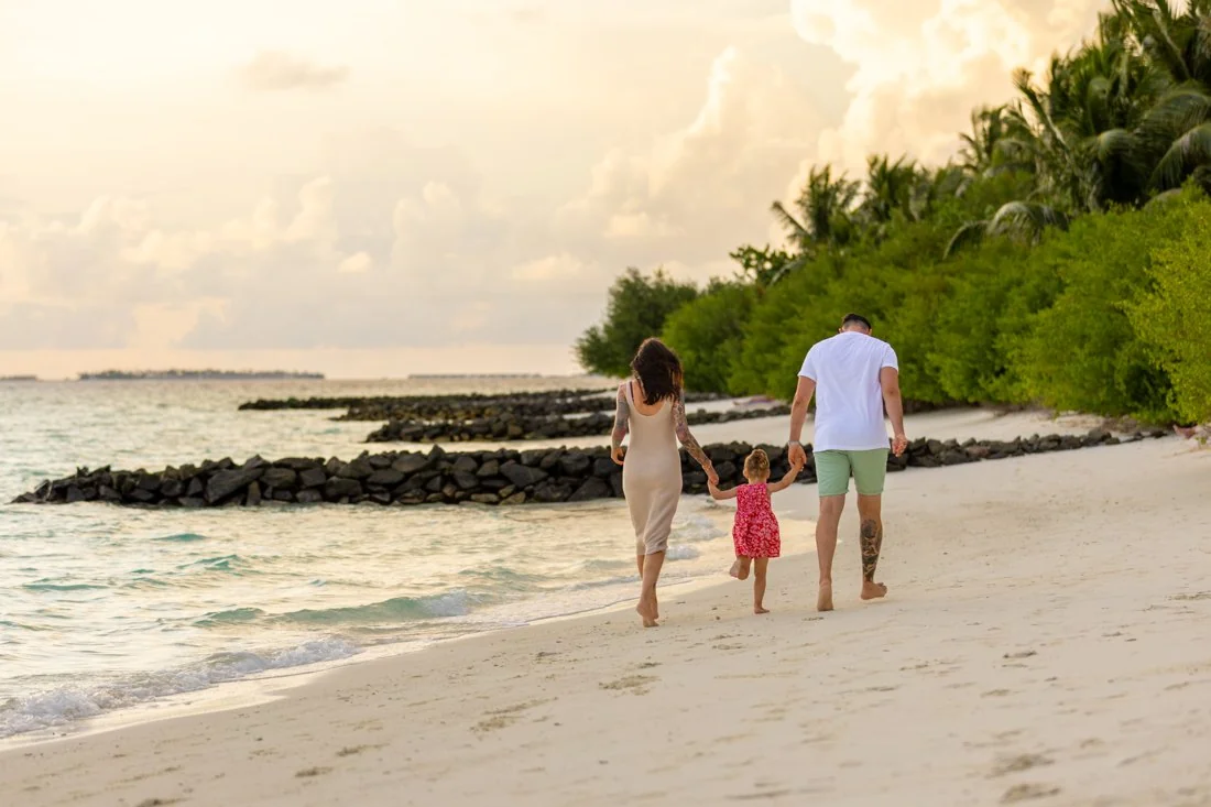 Family walking on the beach at Embudu Village