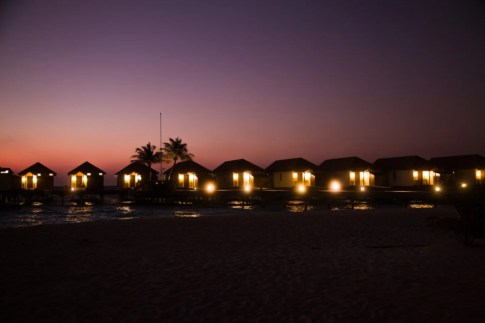 Water villas at sunset at Reethi Faru Resort