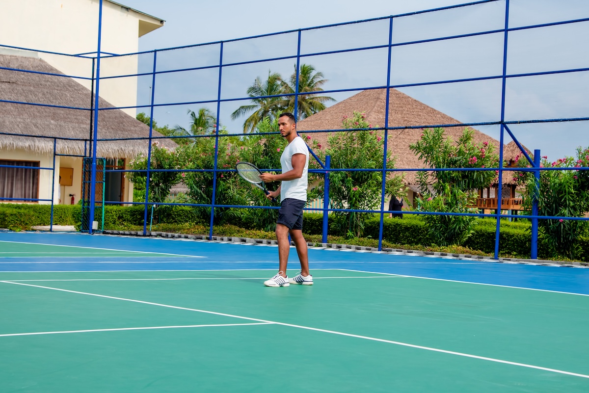 Guest playing tennis at Reethi Faru