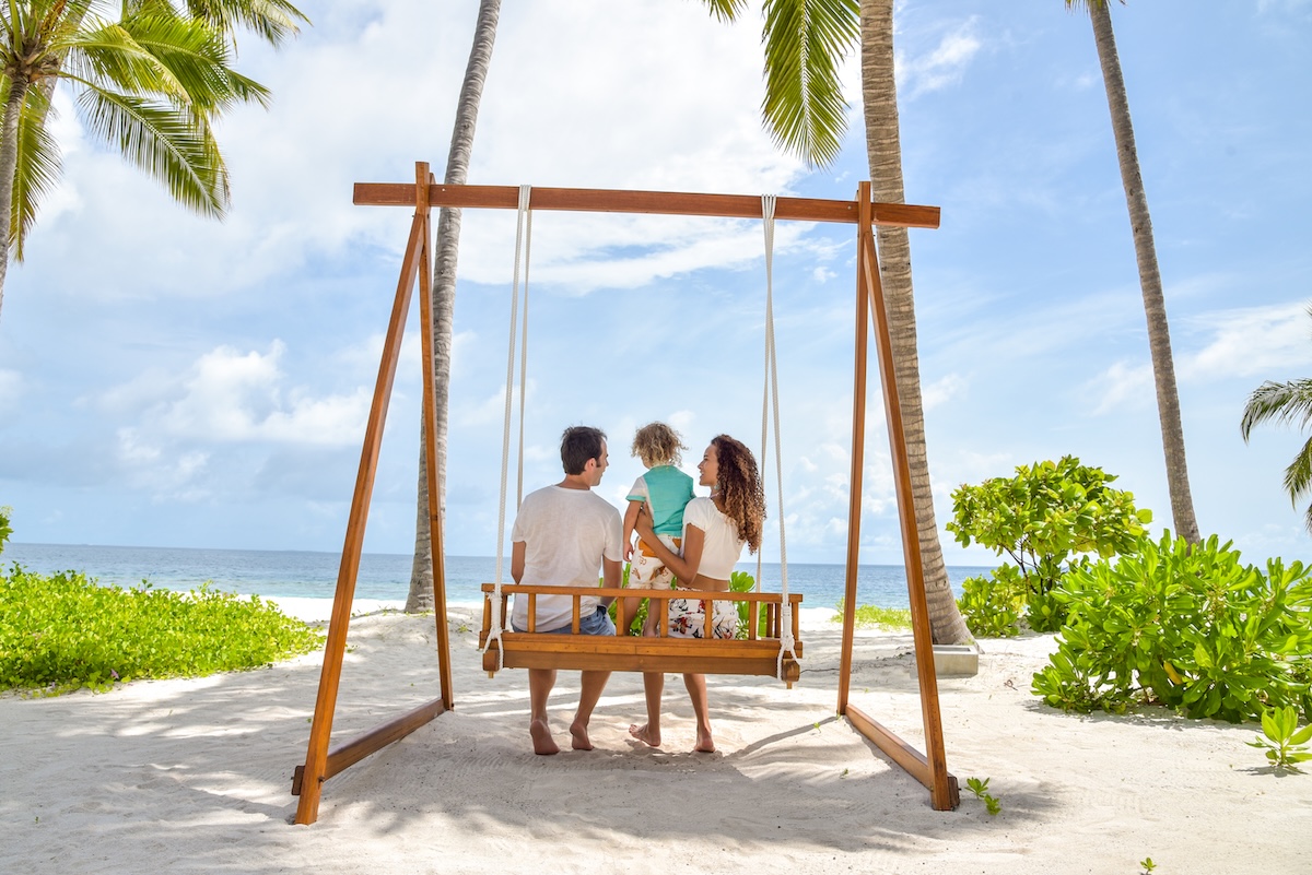 Family enjoying a beach swing at Reethi Faru