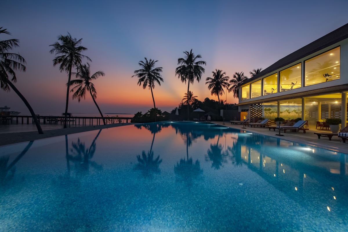 Infinity pool and poolside setting at Reethi Faru Resort
