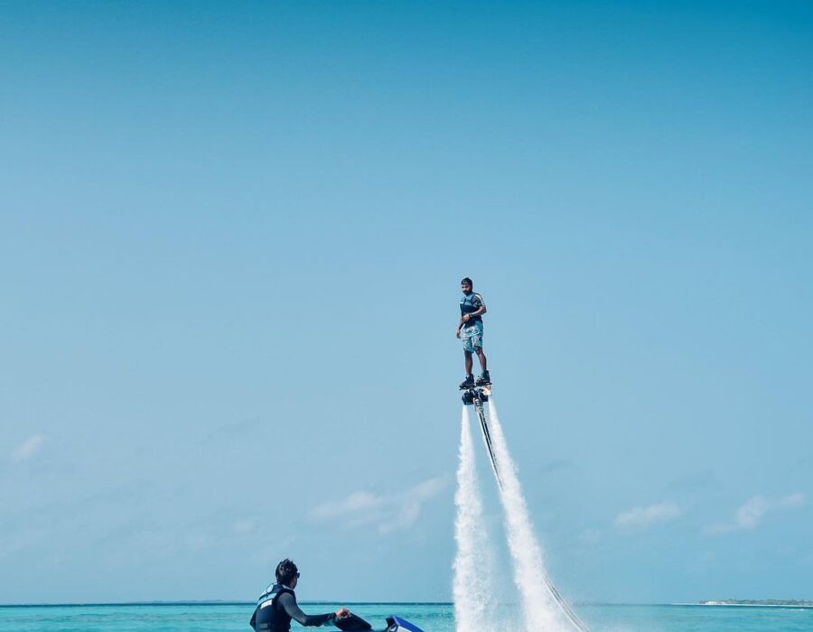 Flyboarder lifted above the water beside a jet ski