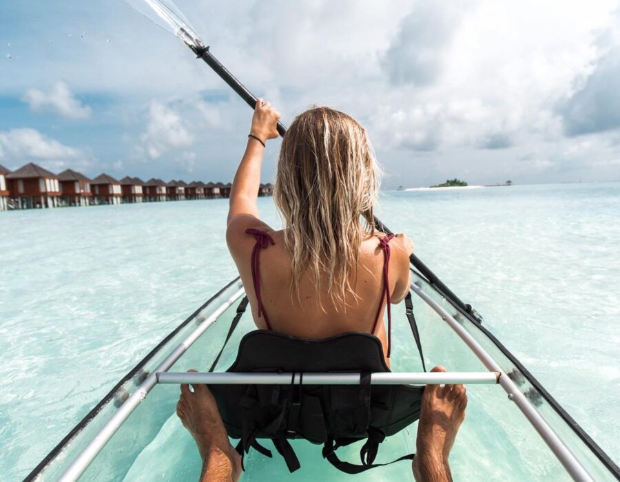 Guest paddling a transparent kayak over the lagoon